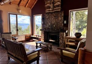 un soggiorno con camino, tavolo e sedie di La Balconada by DOT Boutique a Villa Pehuenia