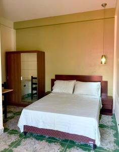 1 dormitorio con 1 cama grande y espejo en Alojamiento céntrico, en Cobija