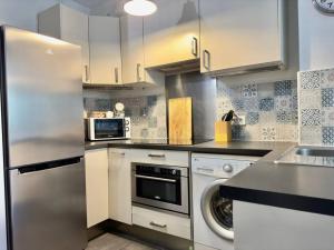een keuken met een roestvrijstalen koelkast en een vaatwasser bij Maison au calme 2 Chambres Terrasse Clim parking gratuit in Montpellier
