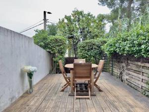 een houten tafel en stoelen op een houten terras bij Maison au calme 2 Chambres Terrasse Clim parking gratuit in Montpellier