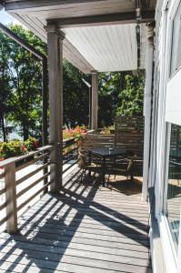 a wooden porch with a picnic table and a bench at The House in Druskininkai