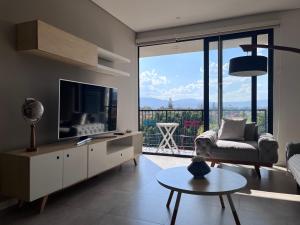 un soggiorno con TV e ampia finestra di Espacio Shanti a Guadalajara