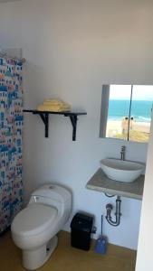 a bathroom with a toilet and a sink at Tayta Surf House in Lobitos