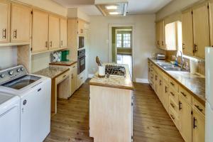 uma grande cozinha com armários de madeira e electrodomésticos brancos em Centrally Located Abilene Abode 2 Mi to Downtown! em Abilene