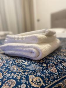 zwei weiße Handtücher auf dem Bett in der Unterkunft White Palace Malpensa in Gallarate