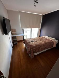 a small bedroom with a bed and a television at Habitación 2 camas + baño privado en Las Condes in Santiago