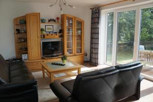 a living room with a couch and a tv and a table at Ferienhaus "SonnenInsel Fehmarn" 9015 - Fehmarn in Fehmarn
