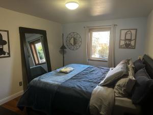 a bedroom with a blue bed and a window at ATTACHED MOTHER-IN-LAW SUITE Soak in the hot tub, star gaze, enjoy the reservoir, hike, bike, kayak and more - Private floor, entrance, terrace and room and bathroom, not the full house in Fort Collins