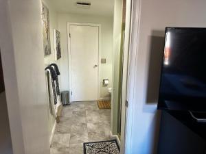 a hallway with a toilet and a white door at ATTACHED MOTHER-IN-LAW SUITE Soak in the hot tub, star gaze, enjoy the reservoir, hike, bike, kayak and more - Private floor, entrance, terrace and room and bathroom, not the full house in Fort Collins