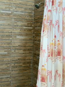 a shower curtain in a bathroom with wooden walls at Tayta Surf House in Lobitos