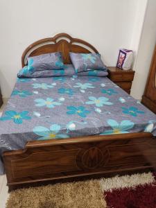 - une chambre avec un lit orné de fleurs bleues dans l'établissement Heliopolis Roxy, au Caire