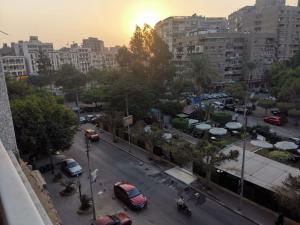 une ville avec des voitures garées dans une rue avec des bâtiments dans l'établissement Heliopolis Roxy, au Caire