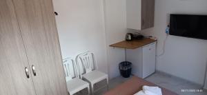 a room with two white chairs and a table at HELEN's ROOM in Artemida
