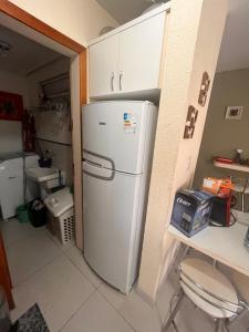 cocina con nevera blanca en una habitación en Apto Jurerê 2 quartos 400m da Praia, en Florianópolis