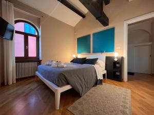 a bedroom with a bed with blue walls and a window at Piazza Erbe Lodge in Verona +55 photos