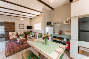 un soggiorno con tavolo e divano di Dennehof Farm Guesthouse a Villiersdorp