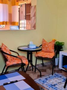 ein Wohnzimmer mit einem Tisch und 2 Stühlen in der Unterkunft Luxe comfort AirBnB by Rosemary in Nairobi
