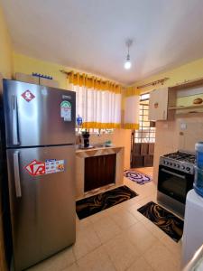 eine Küche mit einem Kühlschrank aus Edelstahl und einem Herd in der Unterkunft Luxe comfort AirBnB by Rosemary in Nairobi