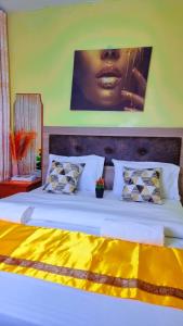 ein Schlafzimmer mit einem großen weißen Bett mit einem Bild an der Wand in der Unterkunft Luxe comfort AirBnB by Rosemary in Nairobi