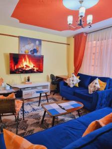 ein Wohnzimmer mit blauen Sofas und einem Kamin in der Unterkunft Luxe comfort AirBnB by Rosemary in Nairobi