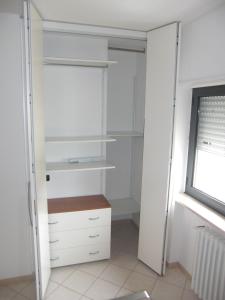 a closet with white shelves and a window at A Casetta in Putignano