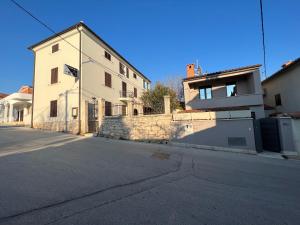 an empty street in front of a white building at Alison Apartments in Premantura