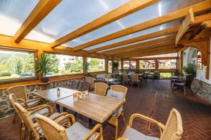 a restaurant with wooden tables and chairs and windows at Pension Big Apple in Železná Ruda