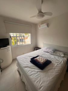 1 dormitorio con 1 cama grande y ventilador de techo en Apto Jurerê 2 quartos 400m da Praia, en Florianópolis