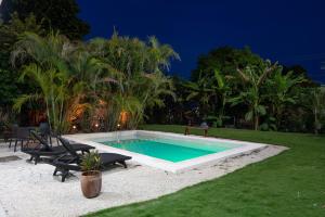 a swimming pool in a yard at night at Hotel Makech in Bacalar