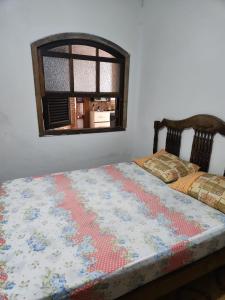 een bed met een dekbed in een slaapkamer bij Suítes Lesther in Ubatuba