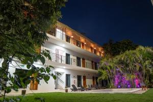 a large white building with a courtyard at night at Hotel Makech in Bacalar