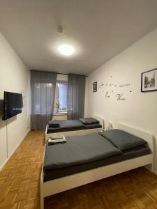 una camera con due letti e una televisione in esso di Ruhrpott Apartment Zentral Smart a Herne