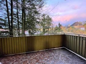 a balcony with a wooden fence and trees at Ruhrpott Apartment Zentral Smart in Herne