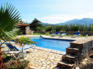 a swimming pool with two chairs at gîte mas d'en pachette in Le Boulou