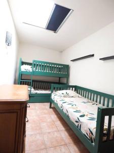 a bedroom with two green bunk beds and a desk at gîte mas d'en pachette in Le Boulou