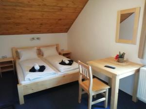 Schlafzimmer mit einem Bett, einem Schreibtisch und einem Tisch in der Unterkunft Pension Big Apple in Železná Ruda