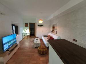 a living room with a couch and a flat screen tv at Casa Jaruf CENTRO HISTÓRICO Parking Gratuito Patio petfriendly in Arcos de la Frontera