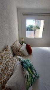 1 dormitorio con 2 camas con almohadas y ventana en Depa Marina Diamante · Depto PB internet Alberca Palapa Acapulco Marina Diamante en Acapulco