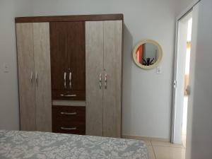 a bedroom with a large wooden cabinet with a mirror at Lar do Sossego in Araquari +8 photos