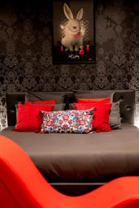 a bed with red pillows and a picture of a rabbit at * Love Room jacuzzi * in Aubie-et-Espessas