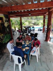 a group of people sitting at a table eating food at Balneario el paraíso in Puerto Triunfo
