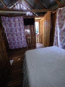 a bedroom with a bed in a wooden cabin at Balneario el paraíso in Puerto Triunfo