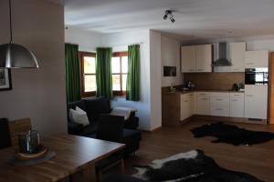 a living room with a table and a kitchen at Apartments Embach in Embach