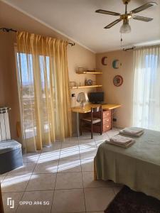 1 dormitorio con escritorio, 1 cama y 1 mesa en La Dimora di Angela, en Amendolara