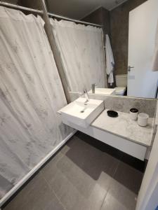 a bathroom with a sink and a shower curtain at Soleado in Buenos Aires
