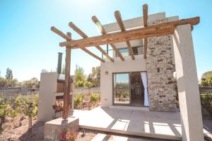 Agrelo Vines Lodge في Agrelo: اطلالة على منزل صغير ذو بنية خشبية