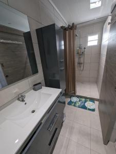 La salle de bains est pourvue d'un lavabo blanc et d'une douche. dans l'établissement Ti Kaz Galet, à La Possession