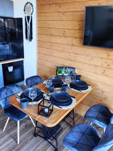 comedor con mesa de madera y sillas azules en Repakowa Chata, en Polańczyk