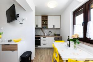 a kitchen and dining room with a table and yellow chairs at Apartment Branko in Lopar