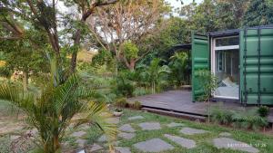 a green house with a wooden deck in a garden at Relajate y disfruta in Santa Cruz de la Sierra